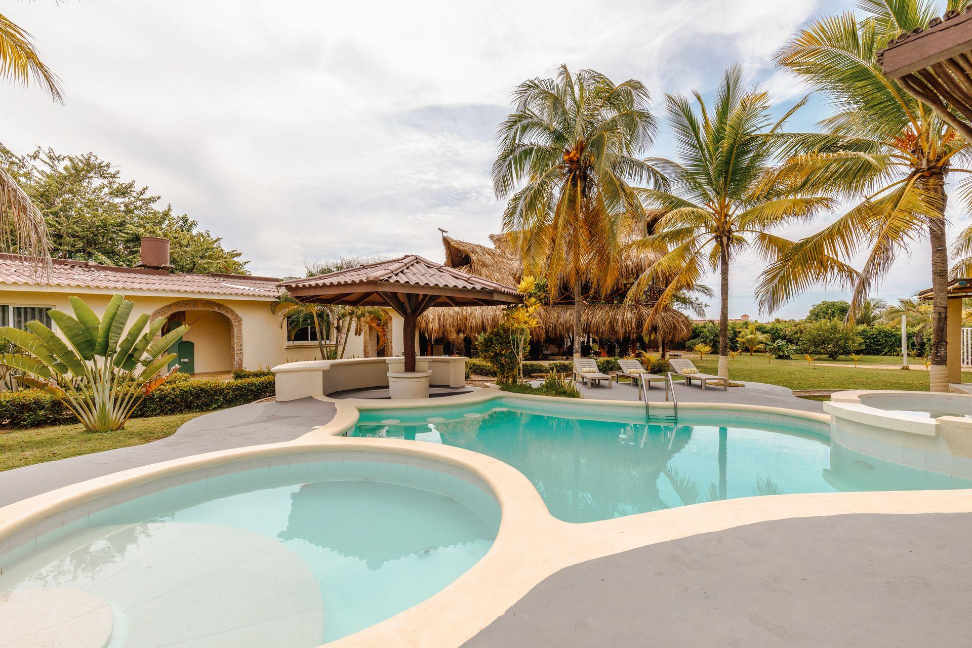 Cabaña tropical en Salinas del Rey con piscina privada, palmeras, bar en la piscina y zona de descanso al aire libre. Un oasis boho-surf para relajarte en el Caribe colombiano.